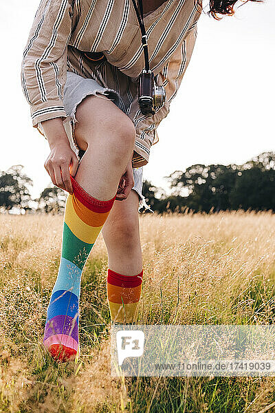 Woman wearing multi colored sock on meadow