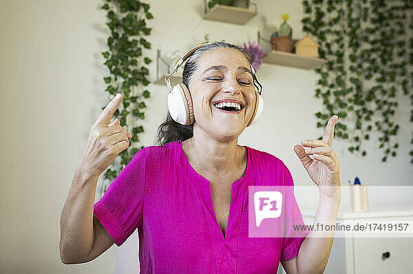 Fröhliche Frau  die Musik genießt  während sie zu Hause tanzt