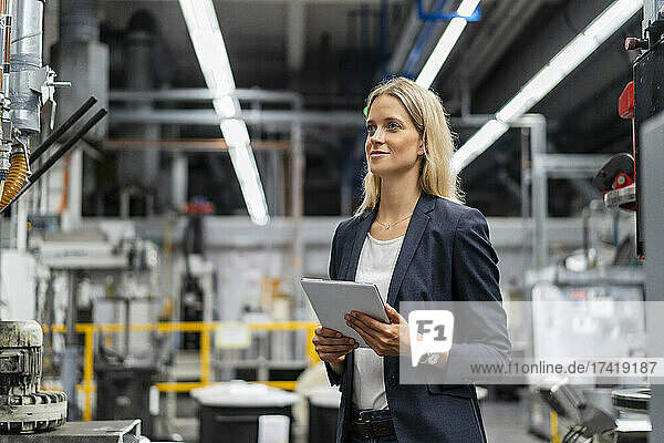 Female business professional with digital tablet in factory
