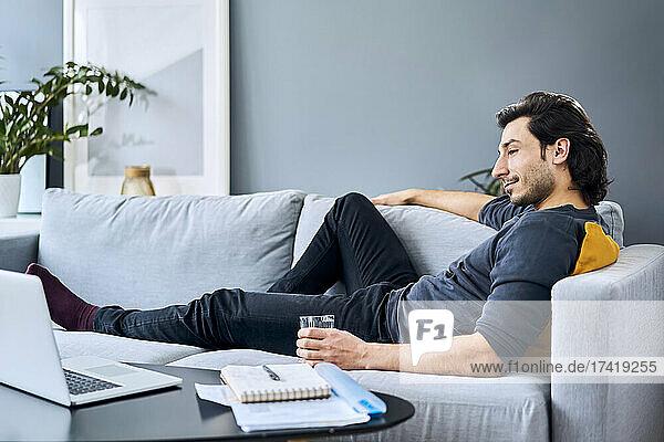 Businessman relaxing on sofa during break while working at home