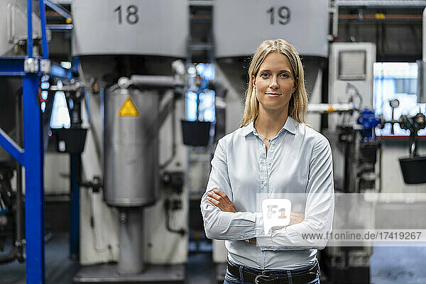Female professional standing with arms crossed at industry