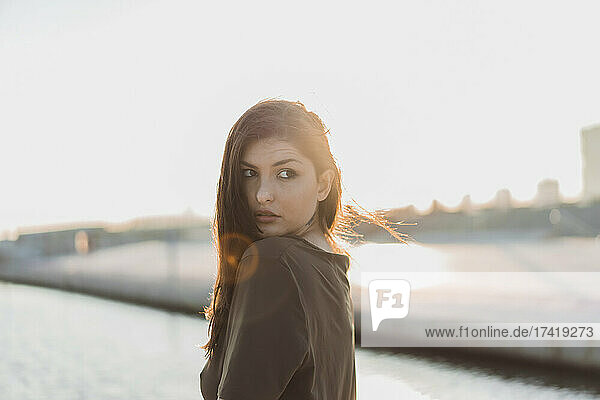 Beautiful woman looking over shoulder during sunset