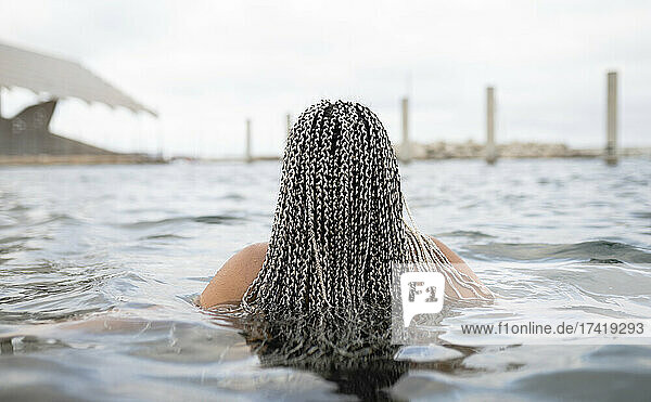 Young woman with braided hair in water during weekend