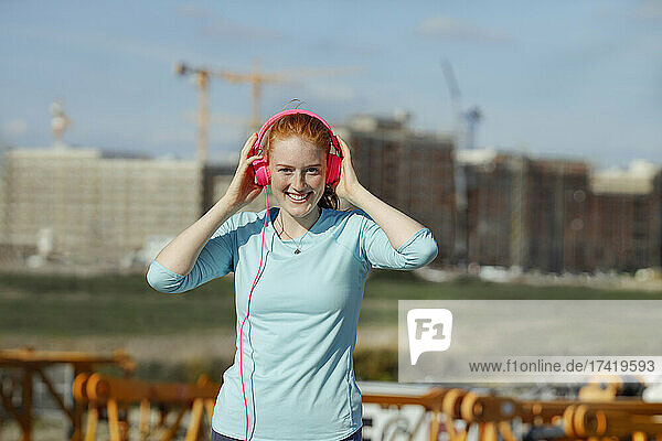 Young woman adjusting headphones at construction site