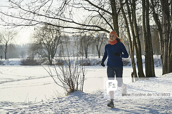 Young woman jogging on snow
