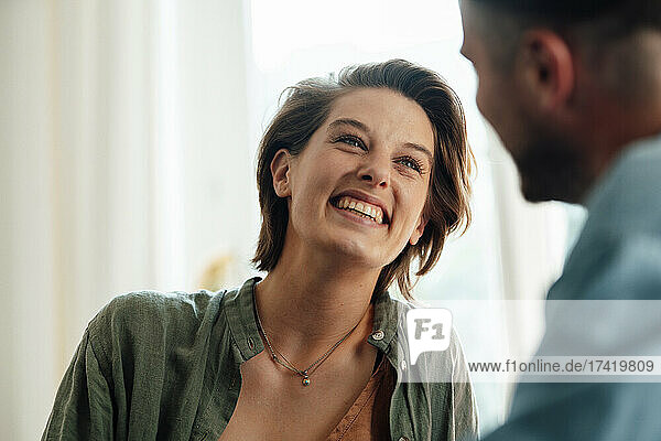 Happy woman looking at man while talking