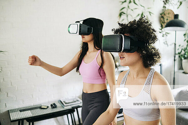 Friends with virtual reality headsets exercising together at home