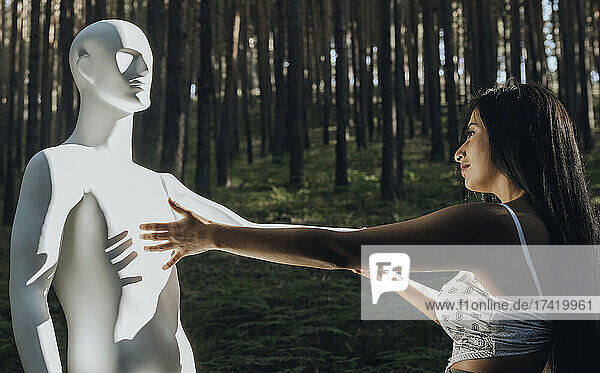Young woman looking at robot during sunny day