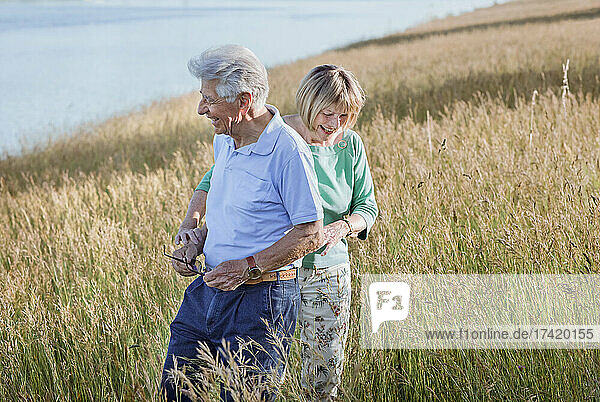 Happy senior couple standing on meadow