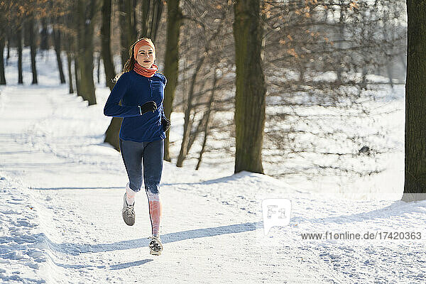 Woman running on footpath during winter