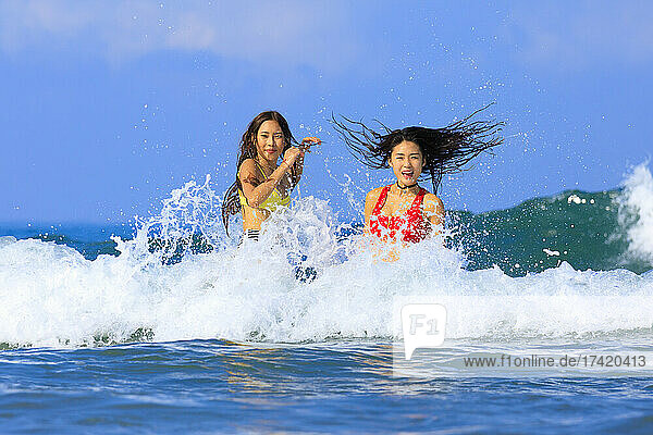 Female friends enjoying in water during sunny day
