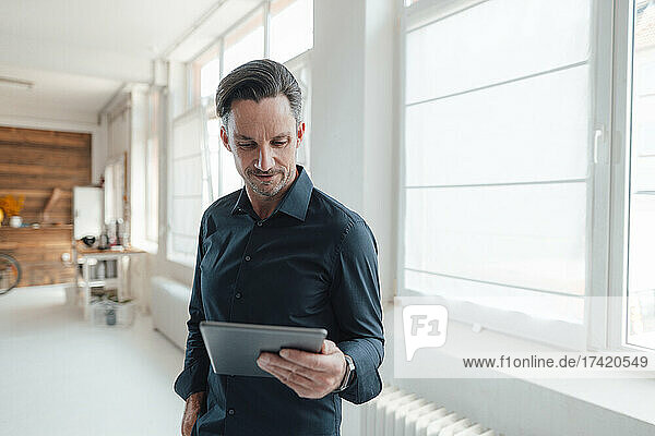 Mature male professional working on digital tablet in office