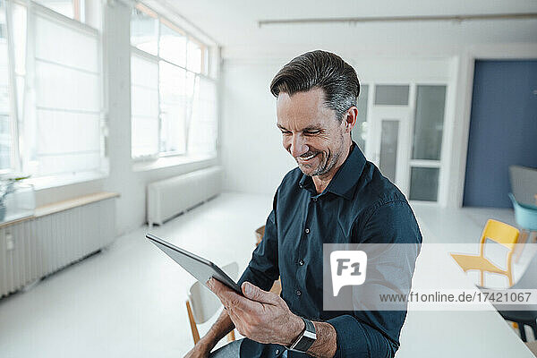 Smiling male professional working on digital tablet in office