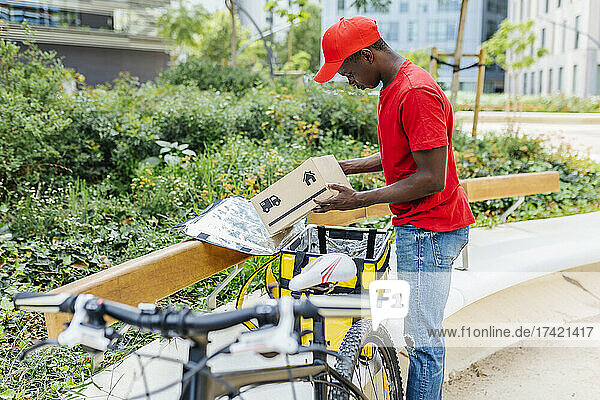 Delivery man examining package at bench
