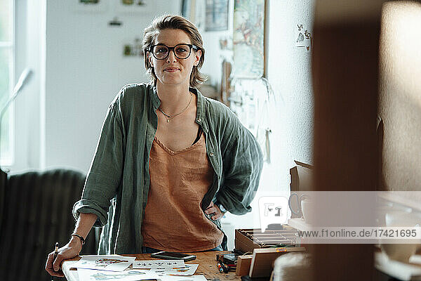 Female illustrator wearing eyeglasses at home office