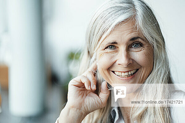 Happy mature woman with gray hair in cafe