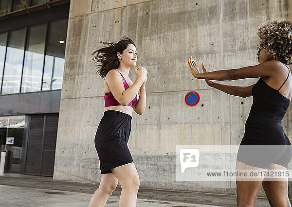 Mid adult women in sports clothing practicing boxing sport