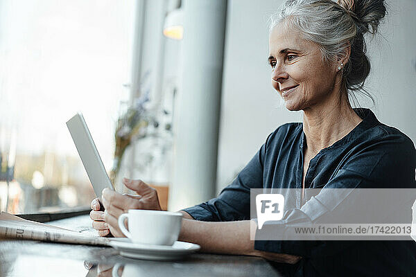 Female freelancer using digital tablet in coffee shop