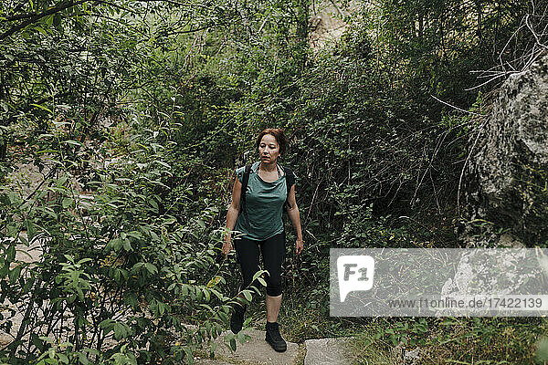 Mid adult woman walking in forest during weekend