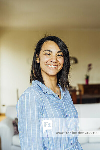 Smiling young woman standing at home