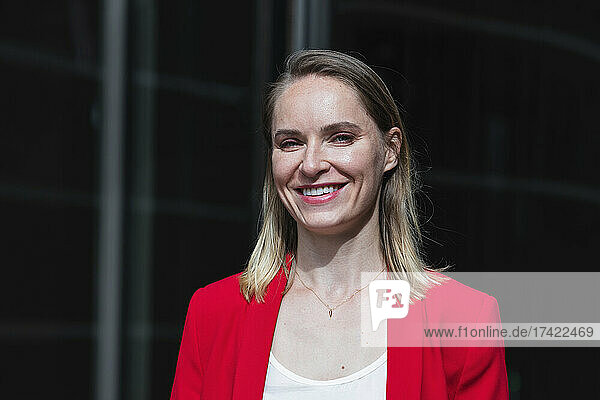 Smiling businesswoman with blond hair on sunny day
