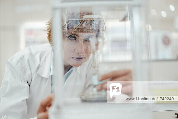 Female pharmacist checking medical equipment while working in pharmacy