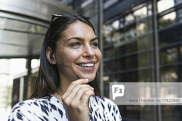 Smiling female freelancer talking through headphones