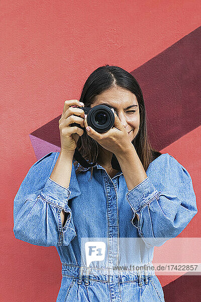 Geschäftsfrau fotografiert mit der Kamera vor der Wand