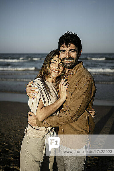 Smiling young couple embracing each other on beach