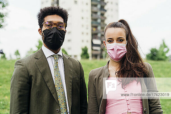 Business professionals with protective face masks at park