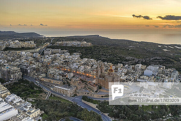 Malta  Northern Region  Mellieha  Aerial view of coastal town at dusk with Parish Church of Nativity of Virgin Mary in center
