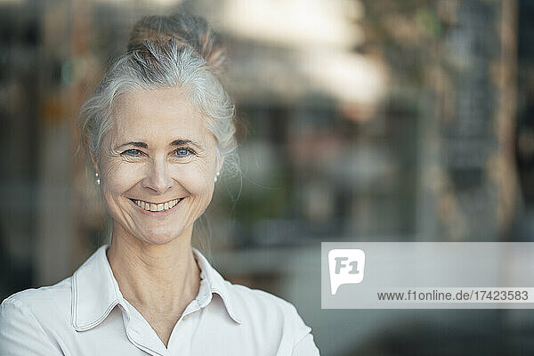 Smiling woman with gray hair bun in cafe