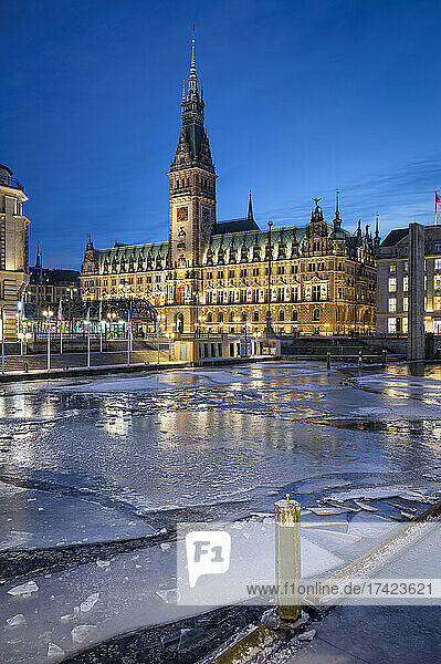 Germany  Hamburg  Ice floating in city canal at dusk with Hamburg City Hall in background