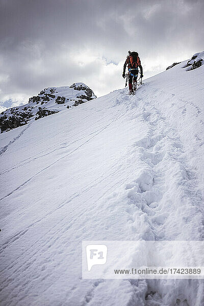 Männlicher Wanderer auf schneebedecktem Berg in den Bergamasker Alpen  Lecco  Italien