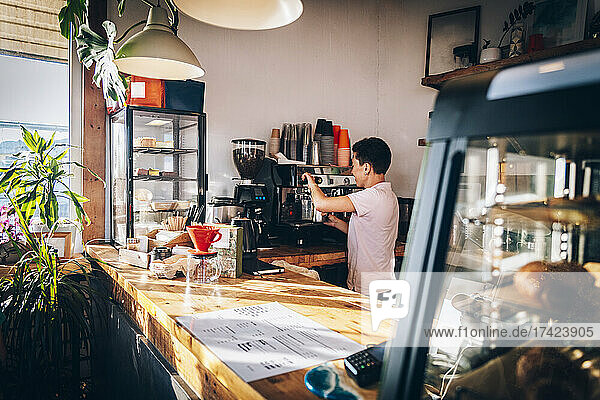 Weibliche Barista kocht Kaffee  während sie im Café arbeitet