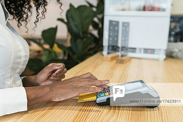 Businesswoman paying through credit card at cafe table