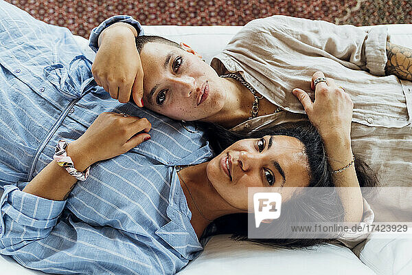 Young lesbian couple lying on sofa at home