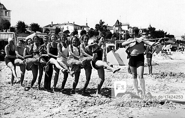Gruppe mit Badenden am Strand  witzig  lachen  Sommerferien  Ferien  Lebensfreude  hoch das Bein  etwa 1930er Jahre  Ostsee  Binz  Rügen  Mecklenburg-Vorpommern  Deutschland  Europa