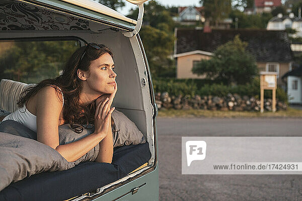 Junge Frau  die während einer Autoreise im Van liegt und nachdenkt