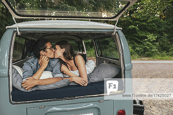 Freundin und Freund küssen sich im Van