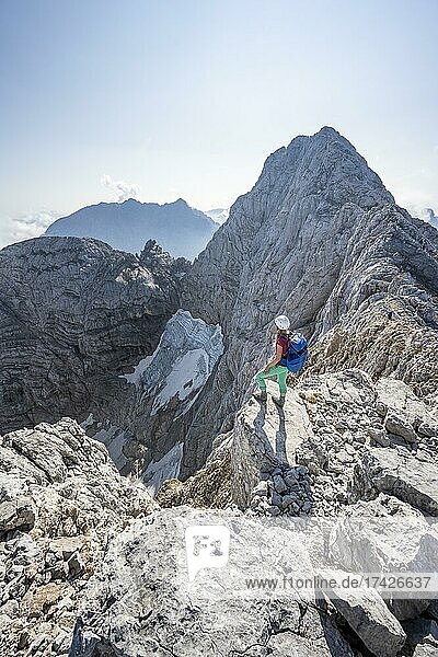 Wanderin an einer Felskante  hinten Hochkalter und Blaueis Gletscher  Wanderung zum Hochkalter  Berchtesgadener Alpen  Berchtesgadener Land  Oberbayern  Bayern  Deutschland  Europa