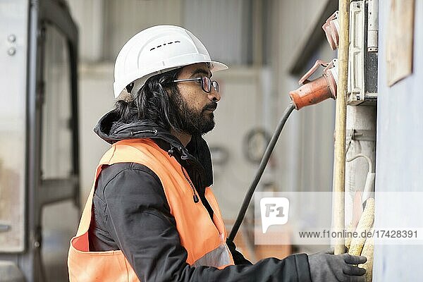 Technician with beard and helmet works in a workshop  Freiburg  Baden-Württemberg  Germany  Europe