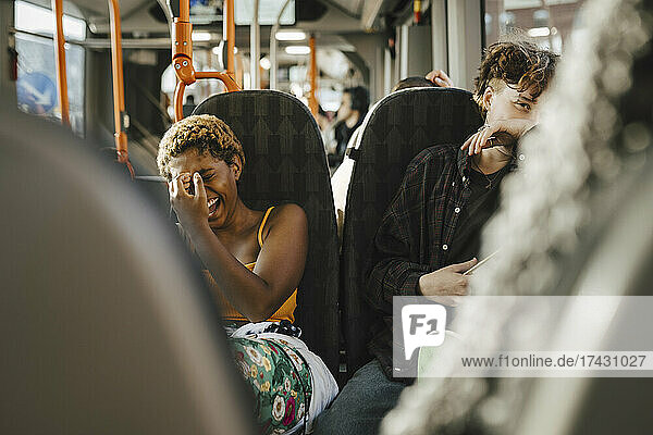 Fröhliche multirassische Freunde  die sich im Bus vergnügen