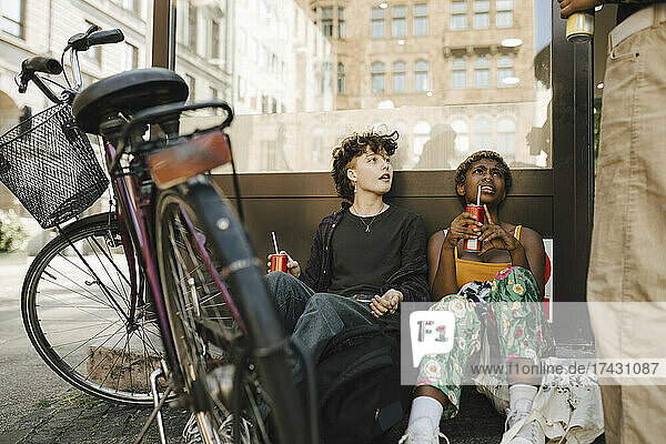 Freunde sitzen mit Fahrrad in der Stadt