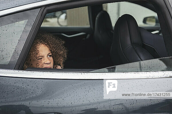 Mädchen schaut durch das Fenster eines Autos