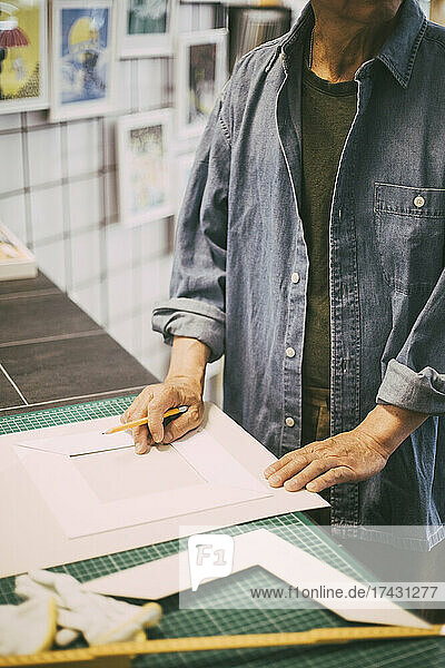 Mittelteil eines Handwerkers mit Papier und Bleistift in einem Einzelhandelsgeschäft