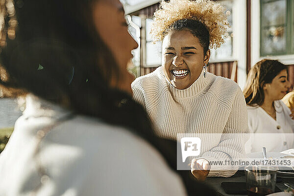 Happy woman talking with female friend in party