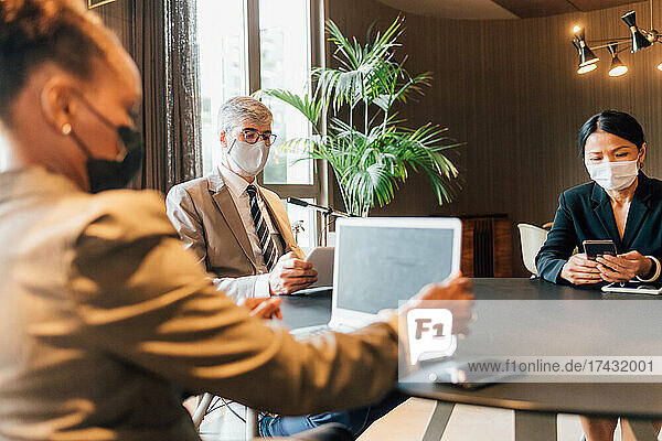 Italy  Business people in face masks having meeting in creative studio