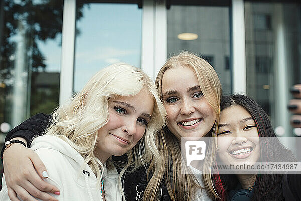 Portrait of smiling female friends outside shopping mall