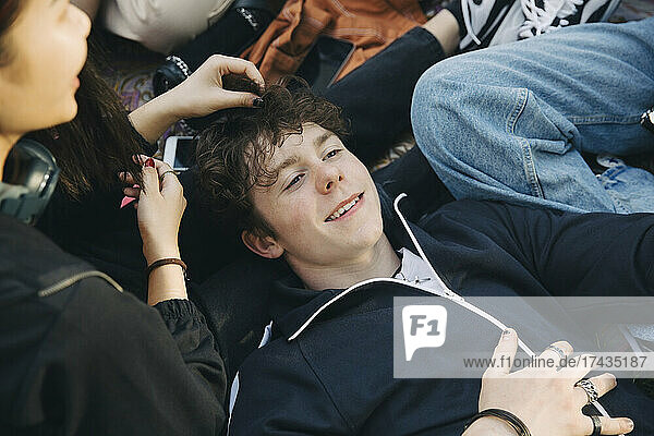 High angle view of teenage boy lying down with friends